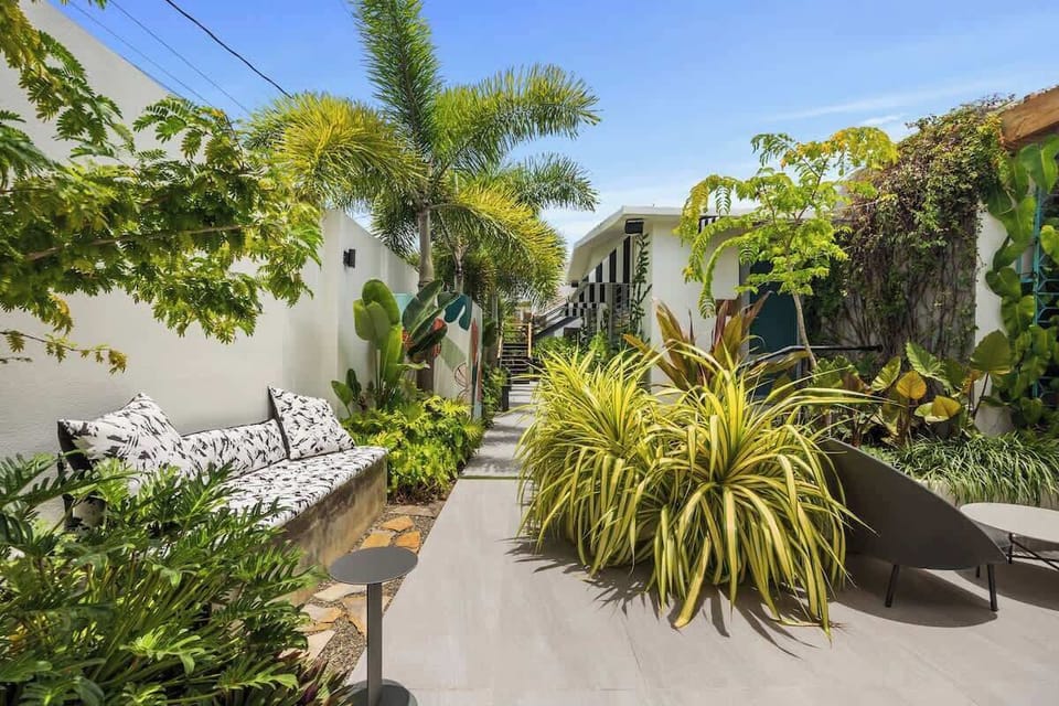 Stylish and comfortable outdoor couch set against a backdrop of exotic plants, creating an urban oasis.
