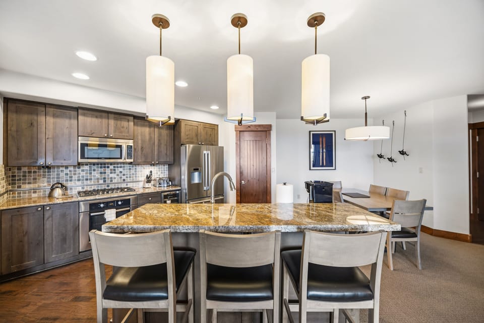Chef's Kitchen: Granite Island, Gas Range & Dining Room Beyond

