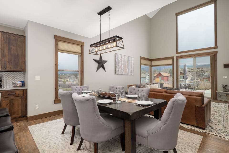 Gather around your elegant dining table with mountain views streaming through expansive windows, creating the perfect backdrop for memorable meals.