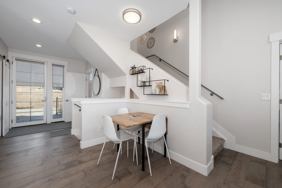Your stylish dining nook awaits beneath the staircase, where natural light streams through French doors onto warm wood floors.
