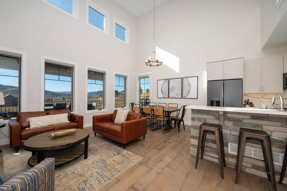Relax in your spacious open-plan living area with soaring ceilings, where leather seating and modern kitchen create the perfect space for gathering.