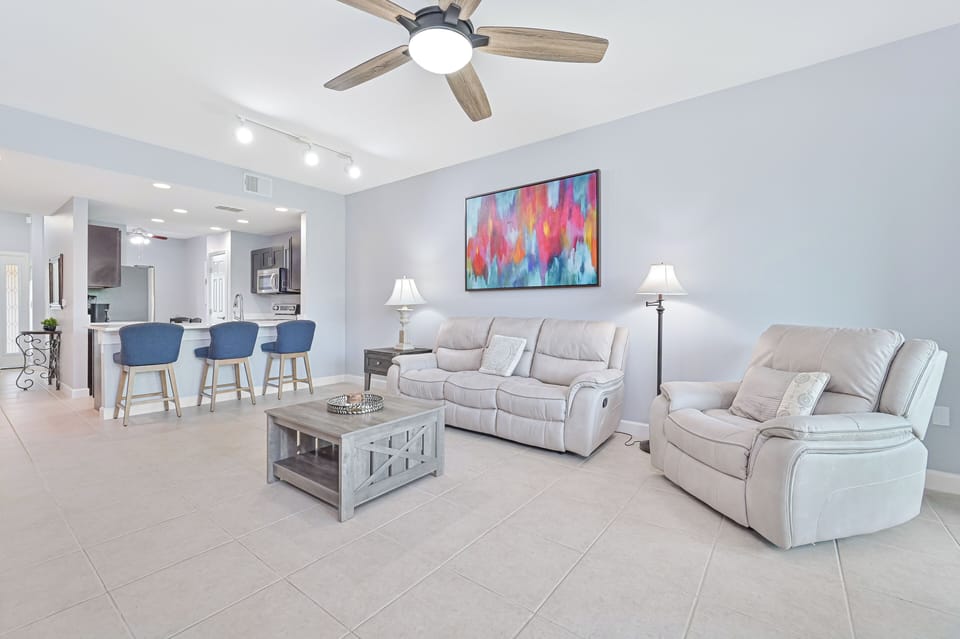 MB102 - Reclining sofa end seats & chair and large smart TV in the living. Sliding doors provide access to the screened in lanai