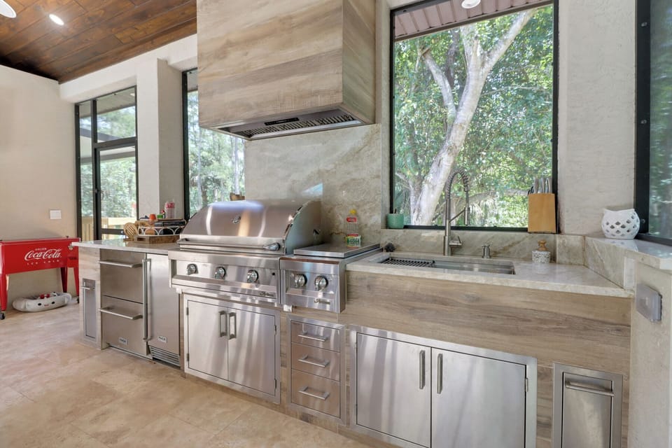 Outdoor kitchen. Includes fridge, ice maker, gas grill w/ burner and large sink.