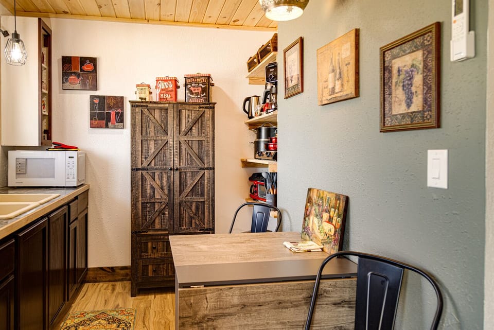 Kitchenette equipped with full fridge, countertop burner, toaster, microwave.