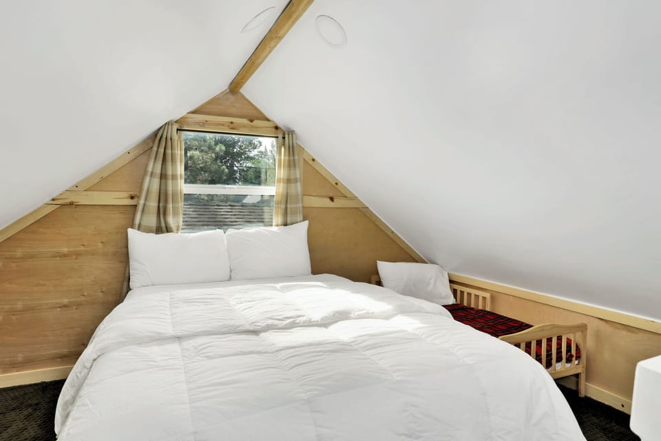 Peaceful cabin bedroom with plush bedding, and beautiful views—ideal for restful nights, cozy mornings, and a relaxing mountain escape.
