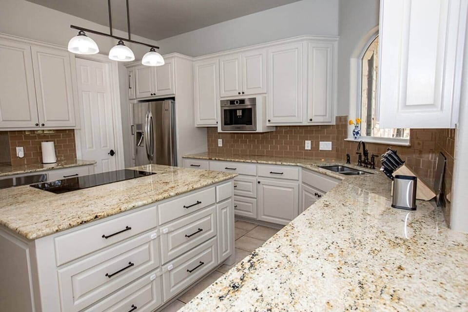 Large modern kitchen with modern appliances including a gourmet coffee maker, double oven, microwave/convection oven, convection stove top.  