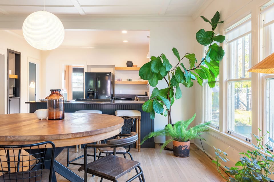 Modern dining area illuminated by a large paper lantern pendant light.