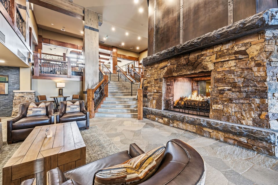 Stacked-stone hearth meets timber staircase in the great room.