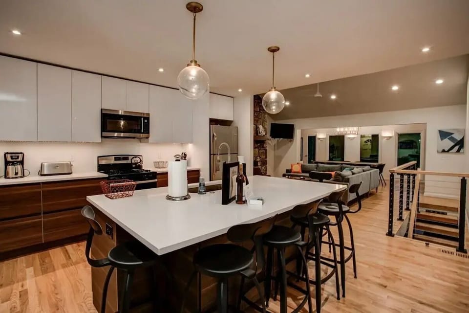 👩‍🍳 Modern kitchen with sleek cabinetry, stainless steel appliances ✨, and a large island with seating for six 🪑—perfect for cooking, dining, and entertaining 🍷.