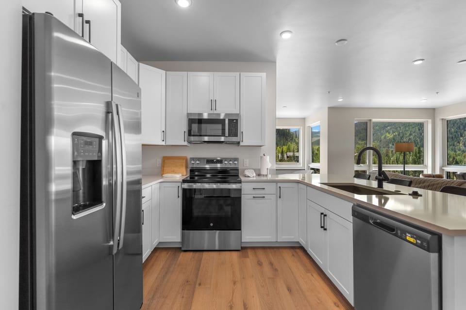 The full kitchen features stainless steel appliances and a breakfast bar with seating for four.