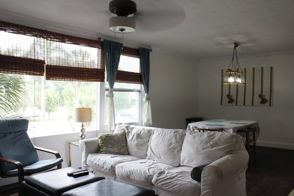  couch, living area, dining table, rocking chair,desk by the window, books