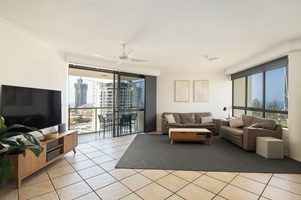 Stretch out in the inviting living area with plush seating, a Smart TV with Netflix, and ocean glimpses through expansive windows.