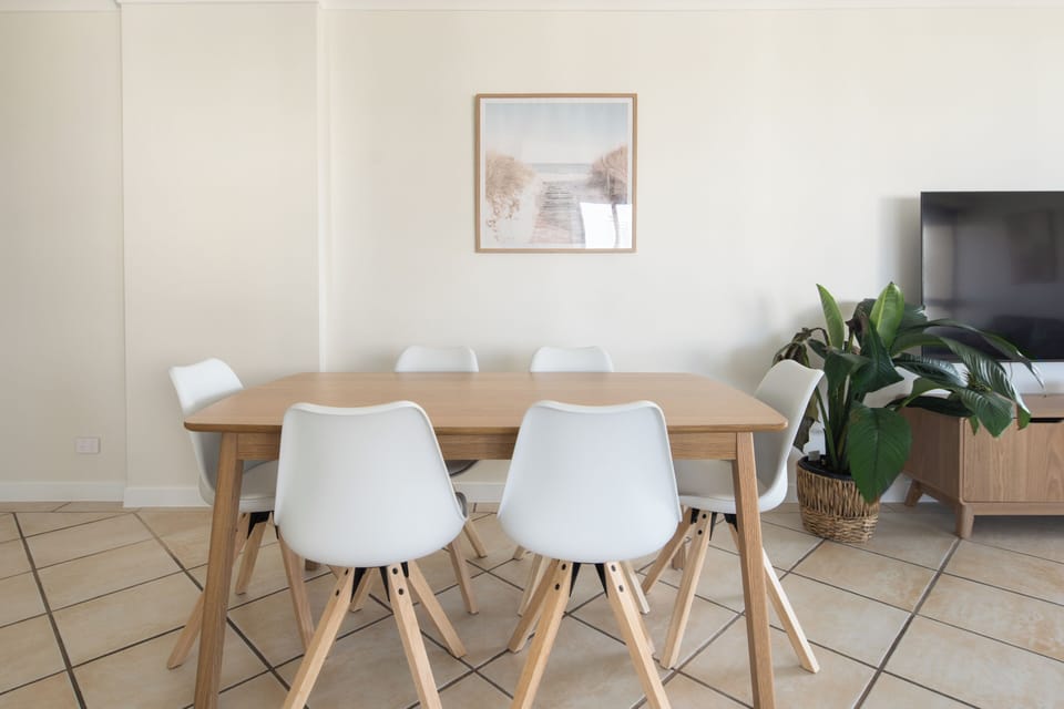 Share meals around the six-seater dining table, bathed in natural light from the expansive windows.