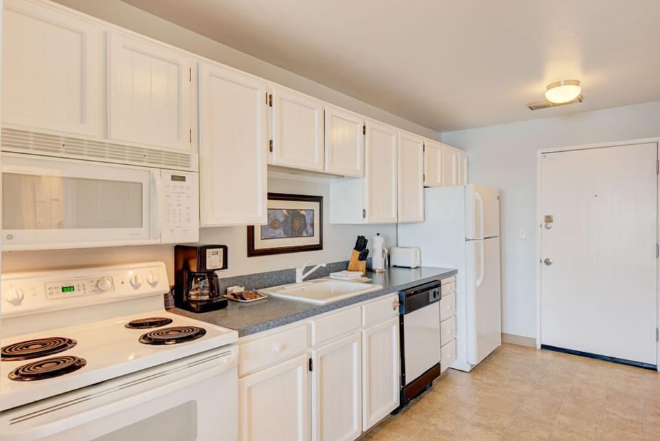 Bright and airy, the fully equipped kitchen offers easy access to the dining area and panoramic ocean views, making it an ideal space for a cozy meal or snack.