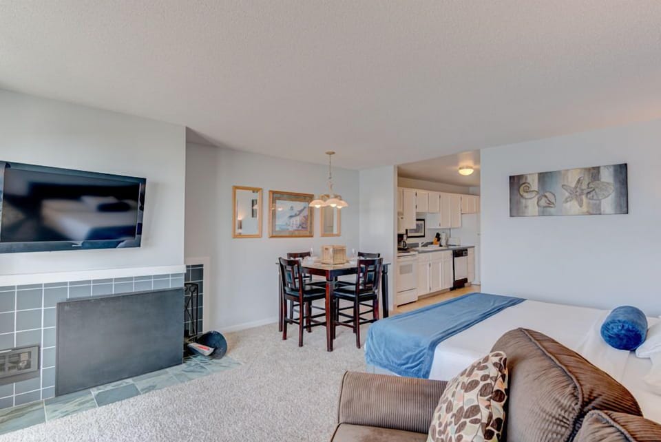 The inviting king bed and stylish seating area complement the panoramic ocean views visible through large windows in this comfortable studio, complete with a well-equipped kitchen.