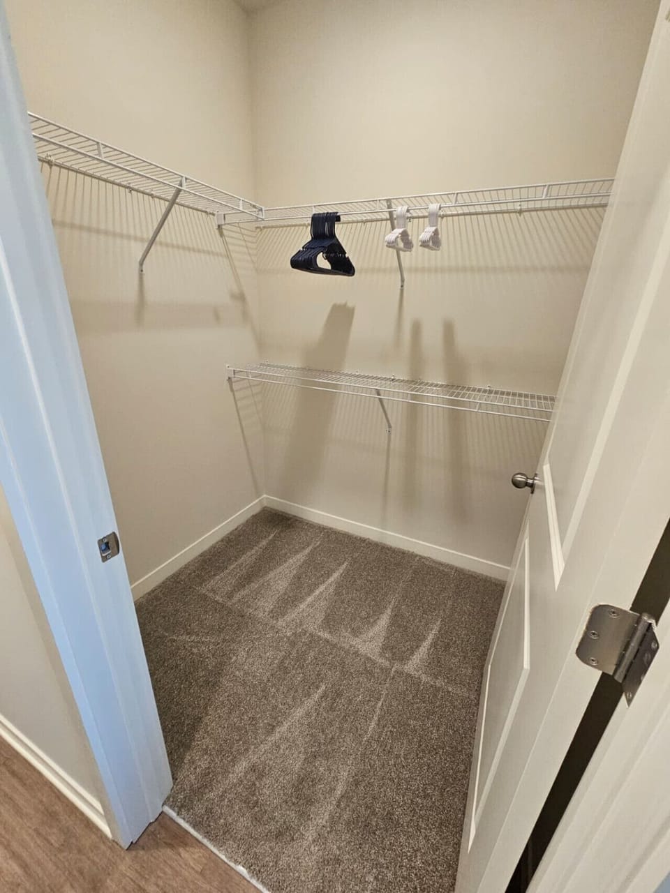 Bright walk-in closet offering ample space and shelving for convenient storage during your stay.