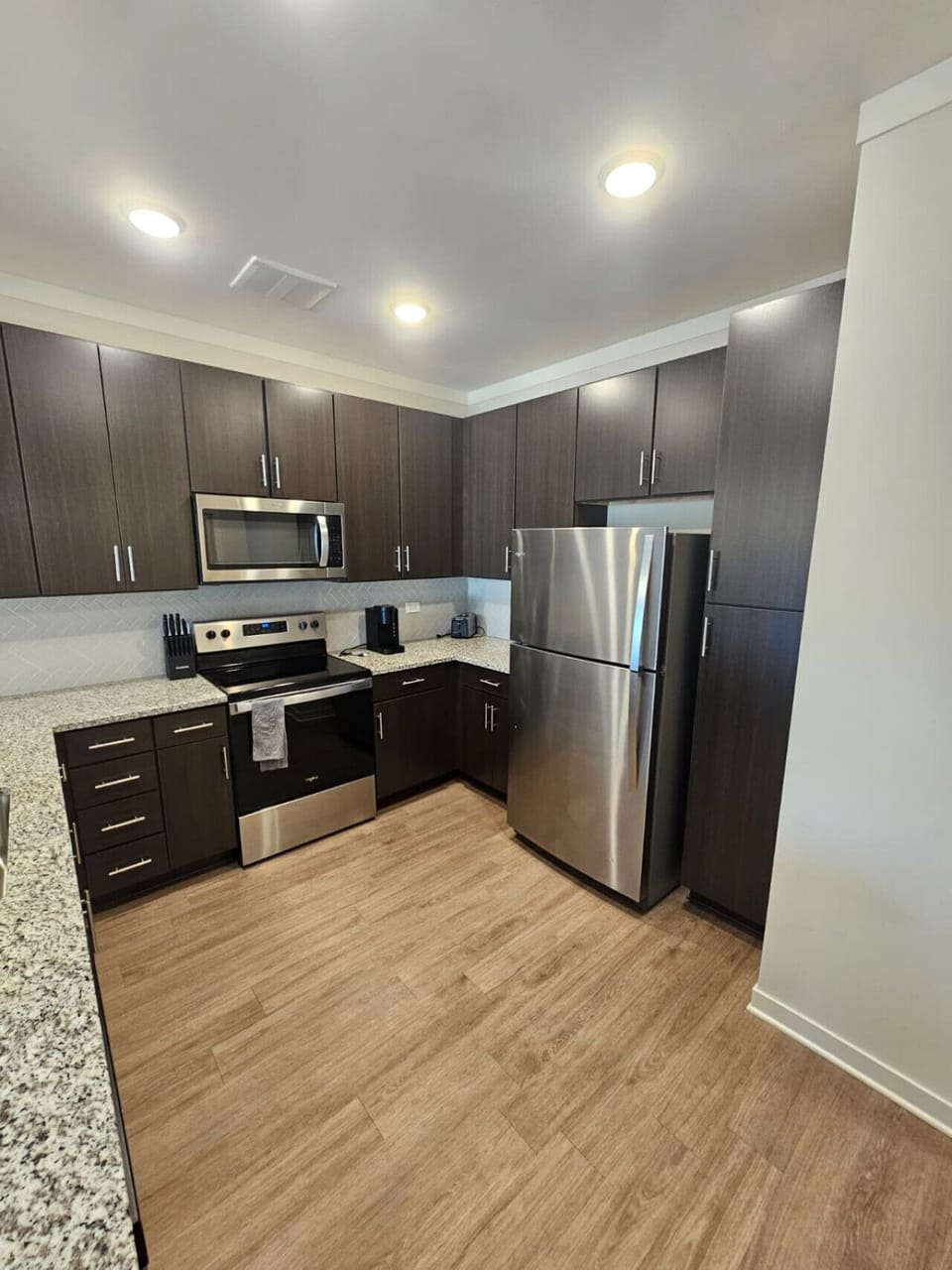 Modern kitchen featuring sleek cabinetry, granite surfaces, and premium stainless-steel appliances for home-style dining.