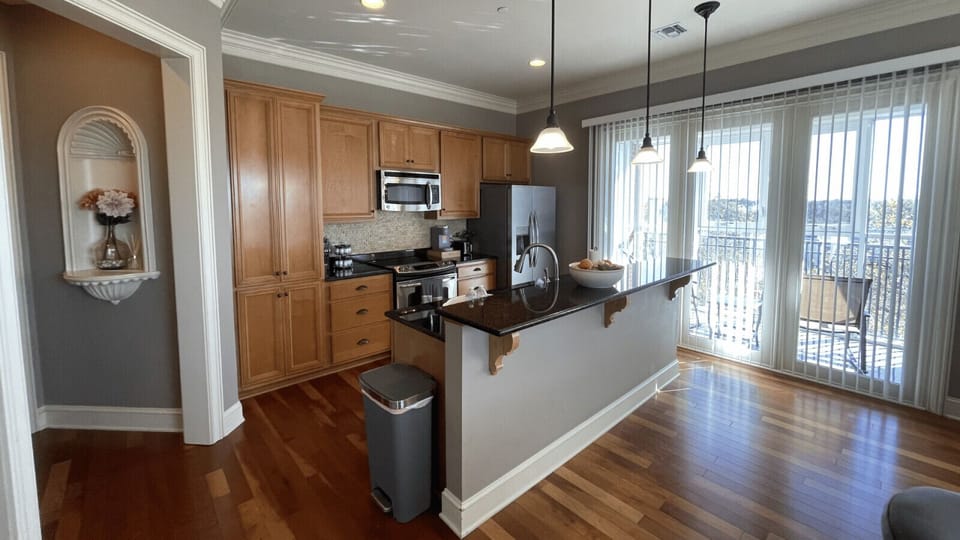 Cook and dine in style! This modern kitchen at The Gateway Village features stainless steel appliances, granite counters, and plenty of natural light for a warm, inviting atmosphere.
