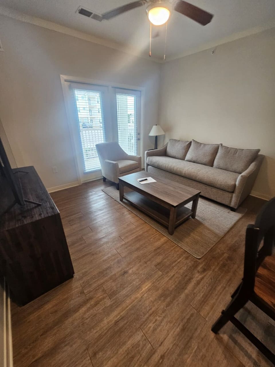 Modern living space featuring comfortable furnishings, large windows, and direct access to the private balcony.