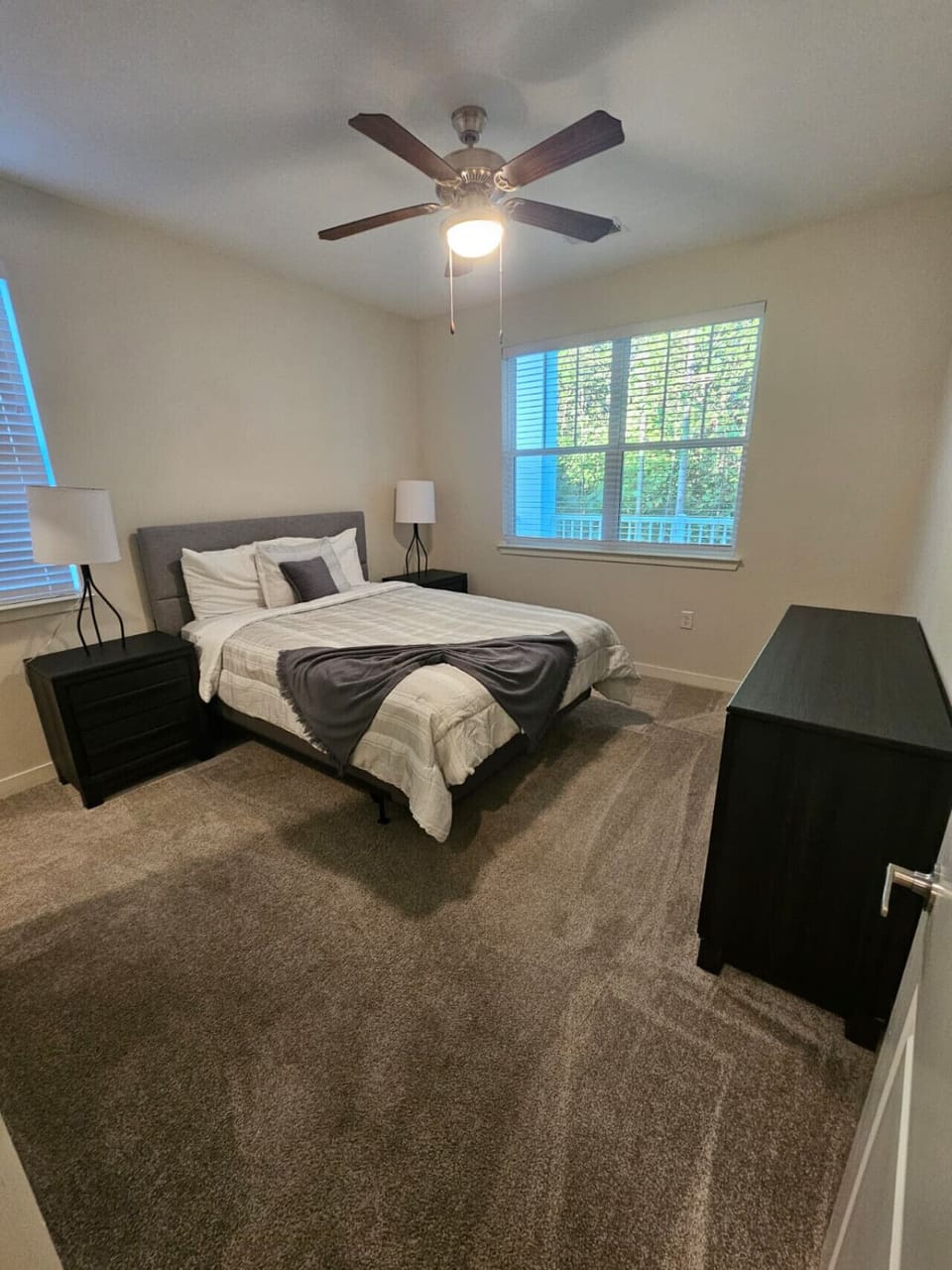 Spacious bedroom featuring a comfortable bed, soft linens, and large windows for a serene atmosphere.