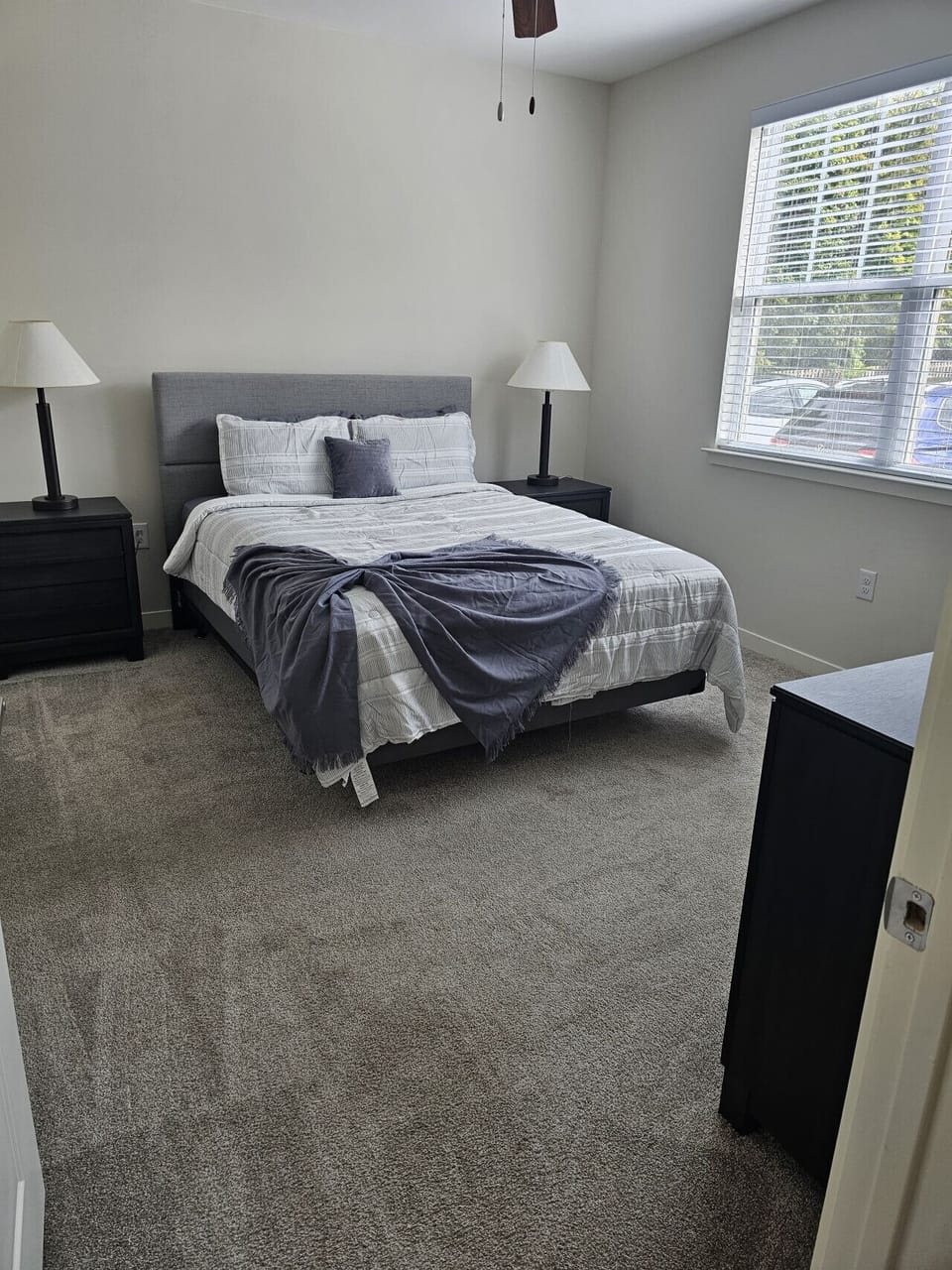 Spacious bedroom with queen bed, nightstands, and lamps.