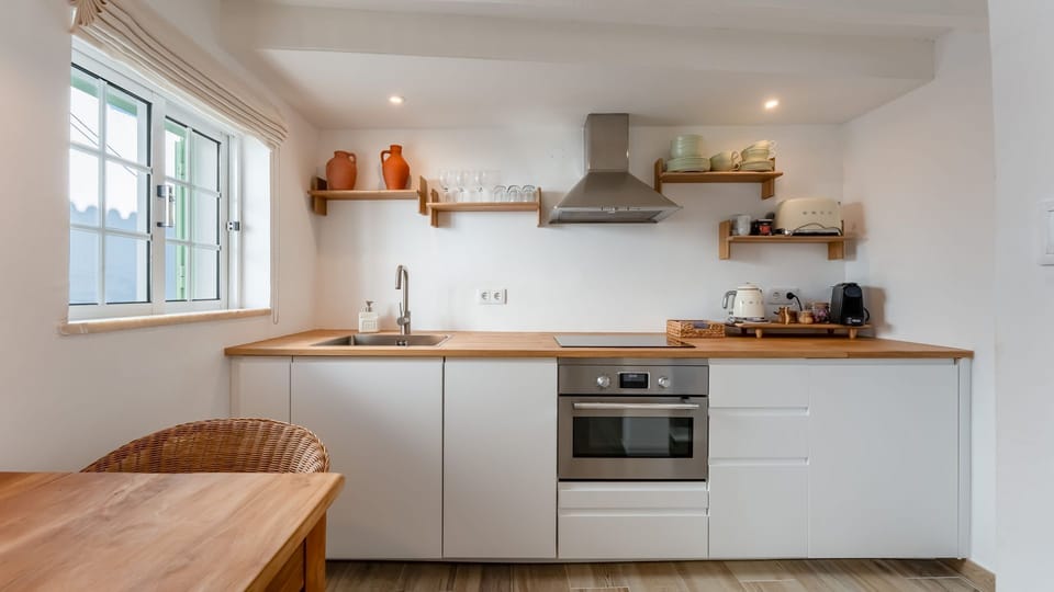 Modern kitchen with sleek appliances and natural wood finishes. Cook like a local in this stylish, functional space.
#ScandiKitchen #AirbnbPortugal #ModernStay
