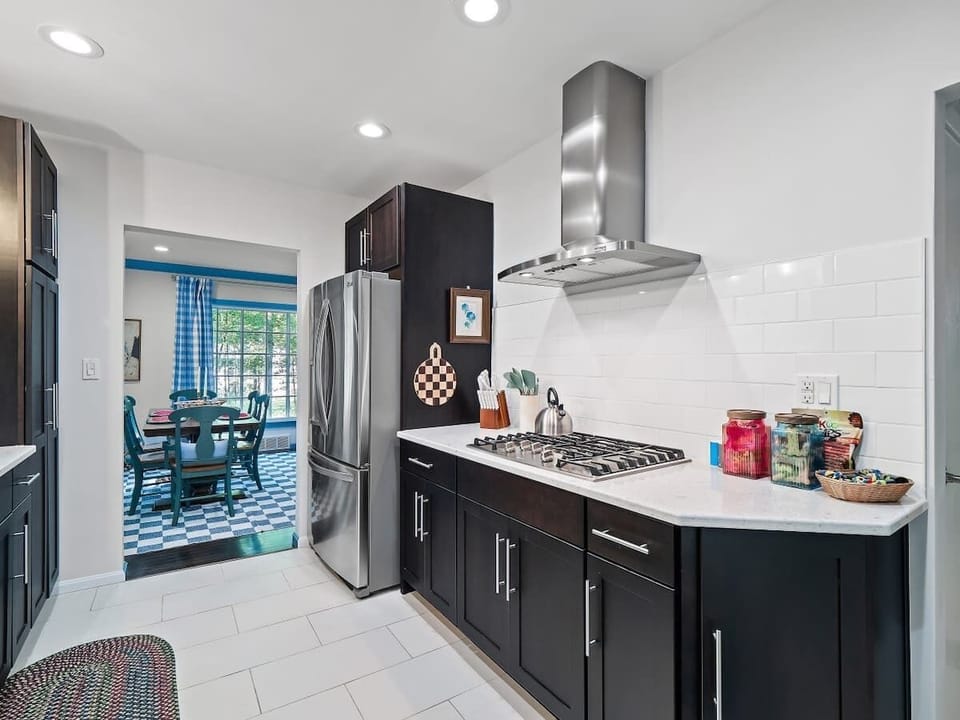 Modern kitchen w/ dark cabinets, stainless appliances & long counter space
