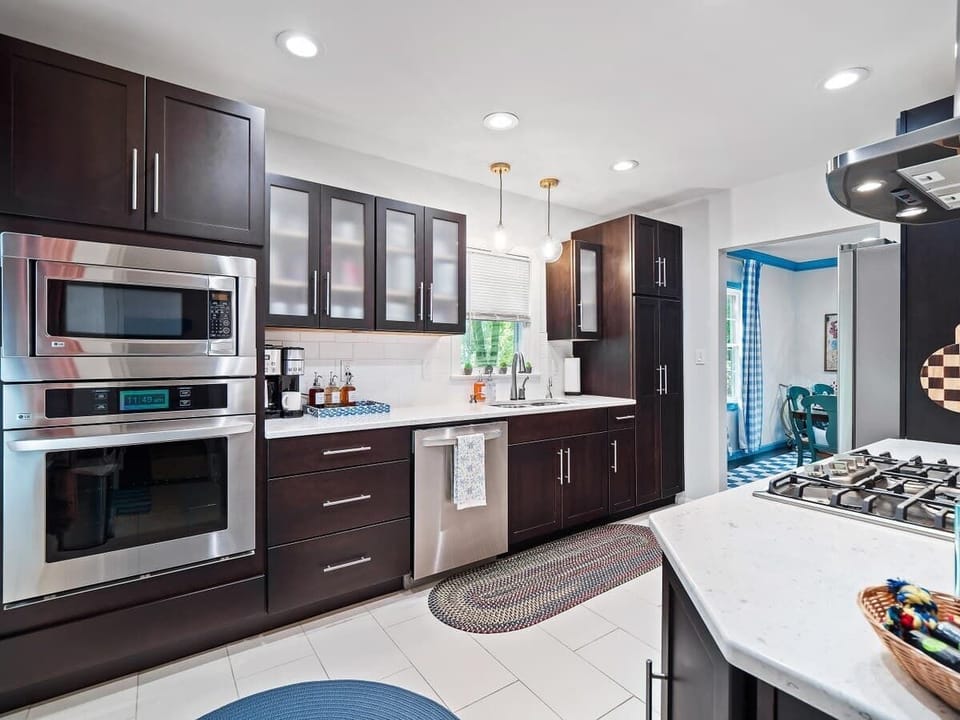 Spacious kitchen w/ dark cabinetry, double ovens & island