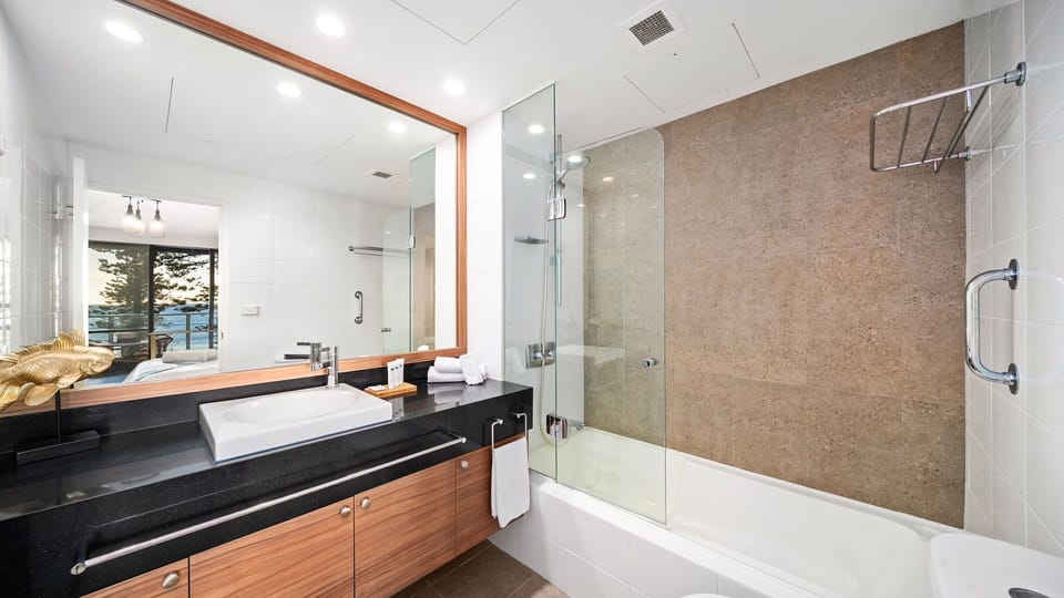 Spacious bathroom featuring a soaking tub and sleek vanity.