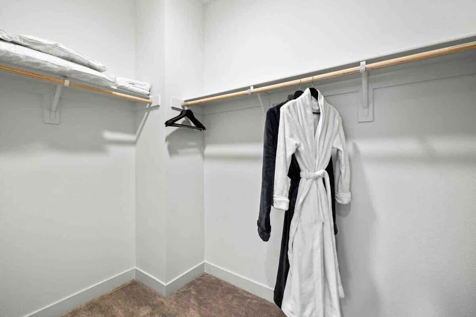 Spacious walk-in closet with robes and storage space