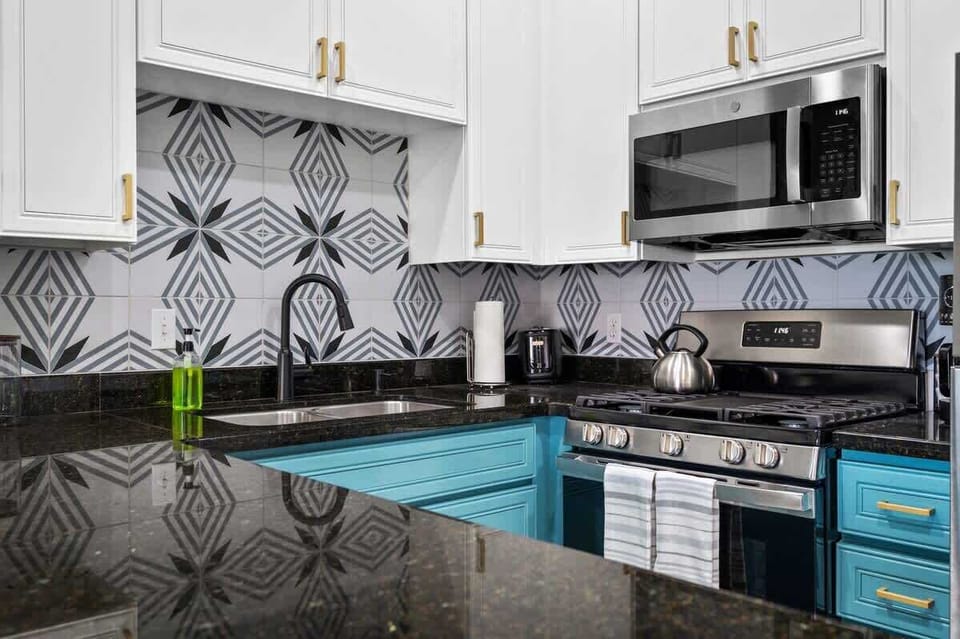 Stylish kitchen with black countertops and white cabinetry