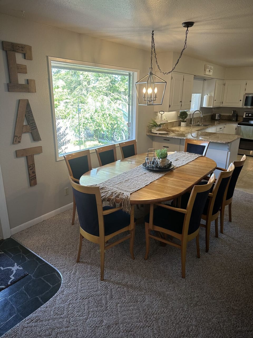 Spacious dining area with expandable table and seating for up to 8 guests.