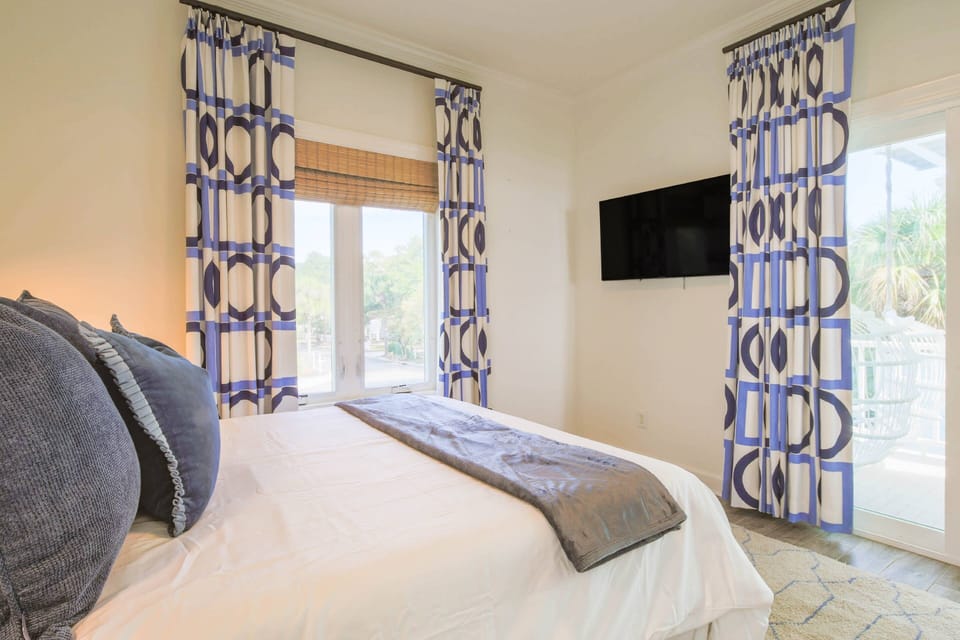 The queen suite features a wall-mounted TV and access to a covered balcony.
