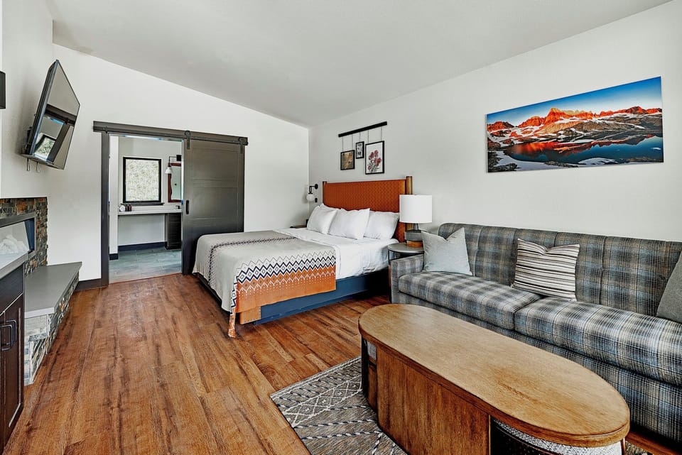 Recharge in a calm bedroom with lounge seating nearby.