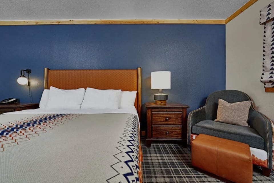 Sink into crisp linens beside warm lighting and plush seating.