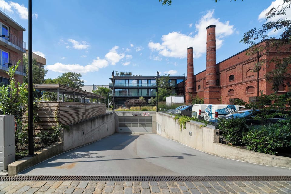 The driveway leads towards the historic buildings, emphasizing the unique atmosphere of the location.