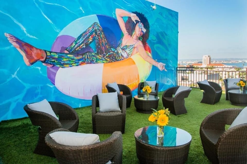Lounge with friends by vibrant rooftop art and skyline.