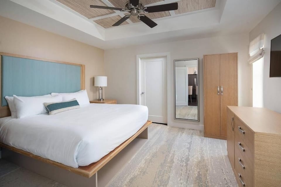 Settle into a bright king bedroom with calm coastal tones.