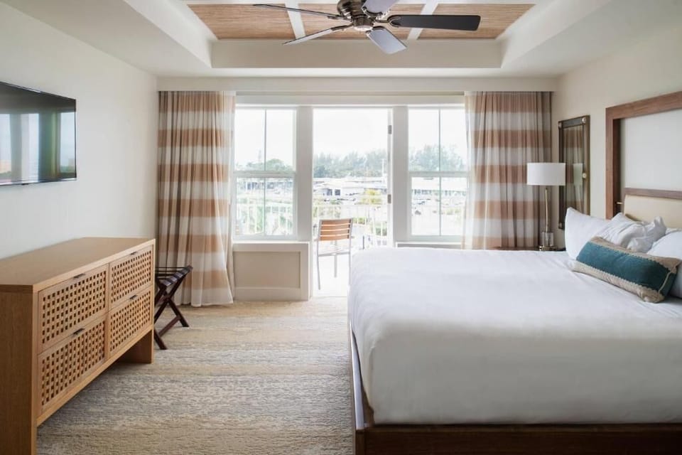 Unwind in a sunlit king bedroom with breezy balcony views.