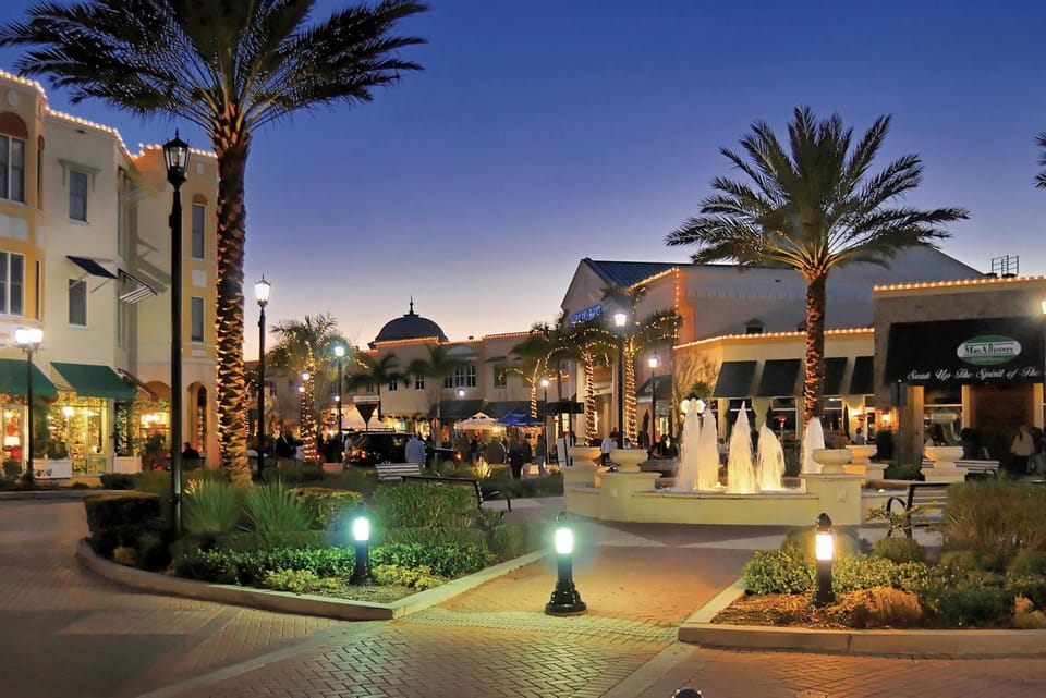 Explore lively evening streets with fountains, shops, and dining nearby.