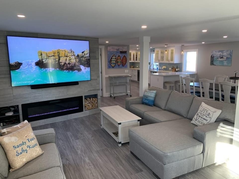 Spacious living area with sectional seating, fireplace, and large-screen TV—perfect for movie nights and gatherings.