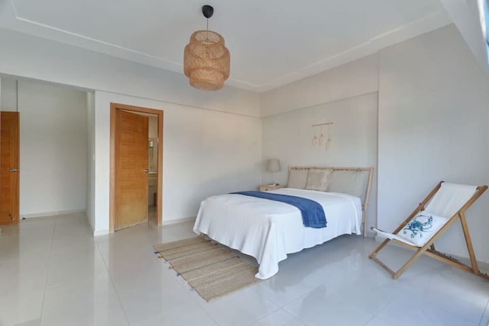 A Queen Size Bed, With A kitchenette and a Workspace Area with 2-chair dining table.