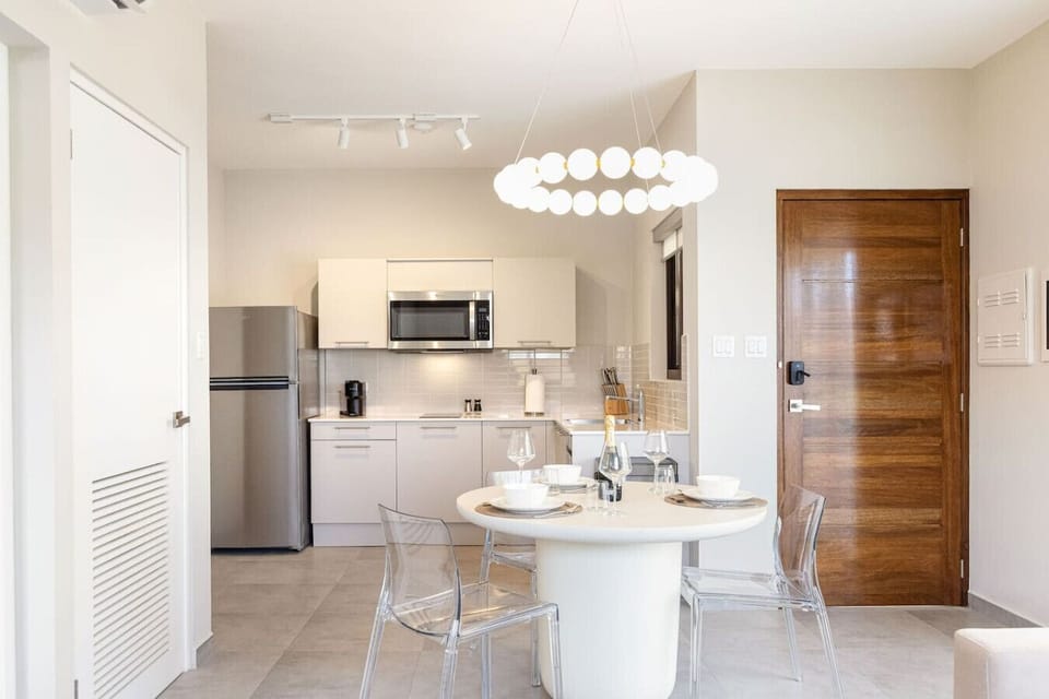 Elevate your dining experience. A sleek round table and stylish transparent chairs sit beneath a stunning geometric ring chandelier, creating the ultimate backdrop for intimate dinners and gatherings.