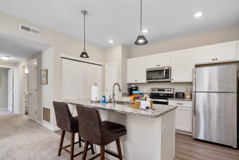 Arhaus bar stools at the kitchen island with spacious granite countertops
