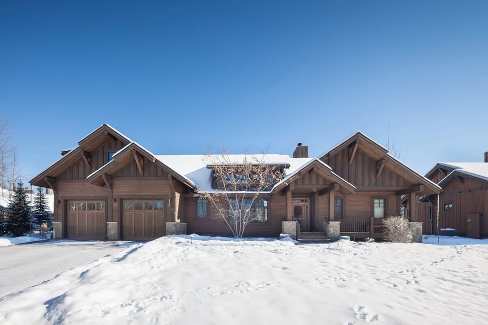 Arrive to a beautiful lodge-style home framed by winter snow.
