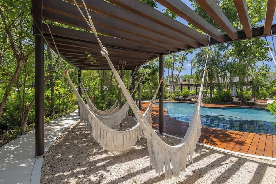 Lovely round shared pool, surrounded by hammocks for relaxing and tables to enjoy a refreshing moment outdoors