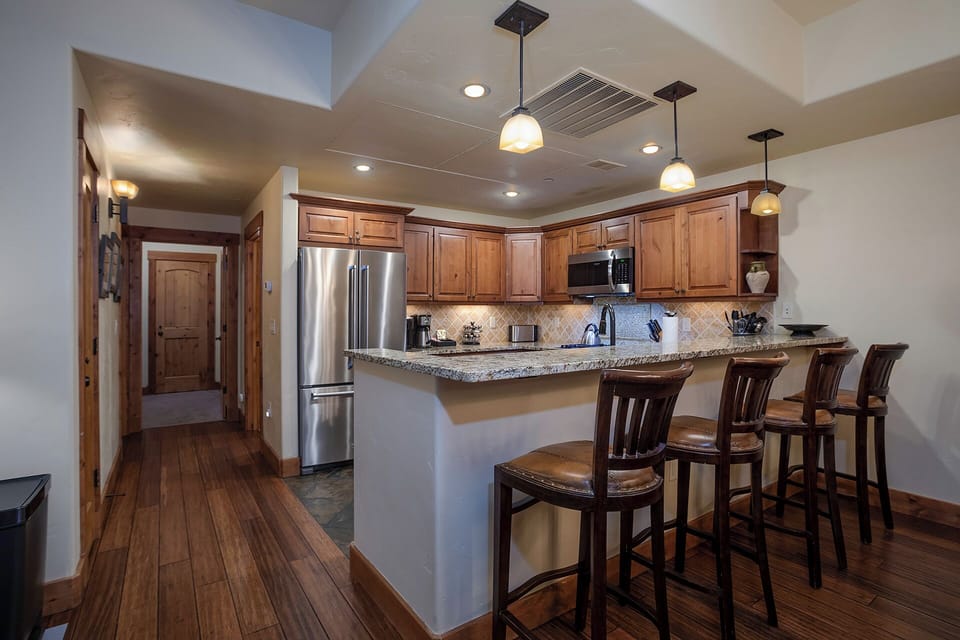 Your fully equipped kitchen features granite countertops, stainless steel appliances, and a breakfast bar where you can sip morning coffee.
