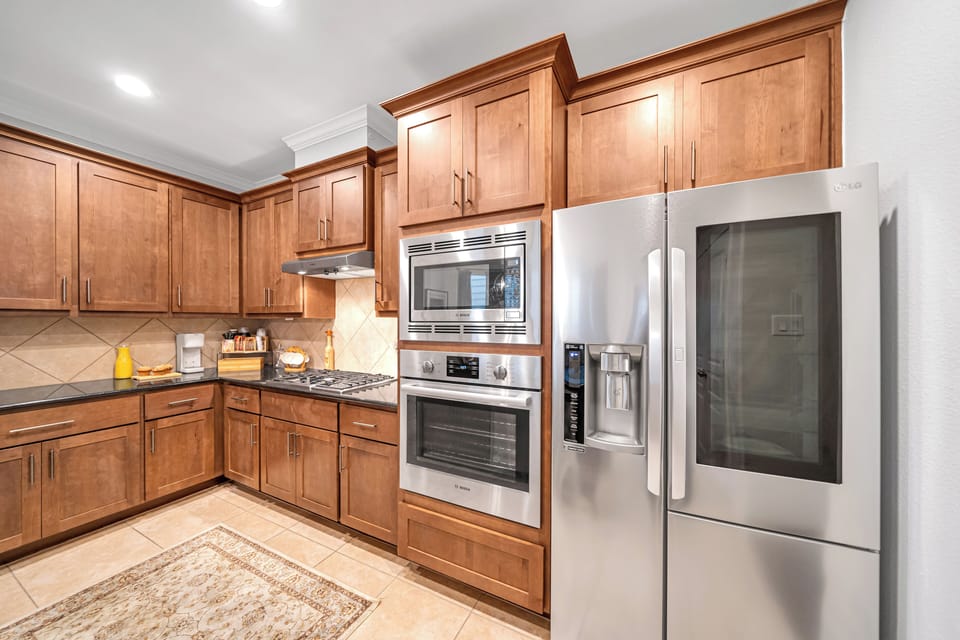 Gourmet kitchen with stainless steel double oven and modern refrigerator.