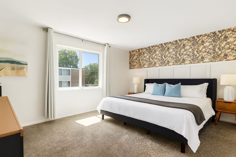 Bright and airy bedroom with large windows, a king bed, and modern art for a peaceful vibe.