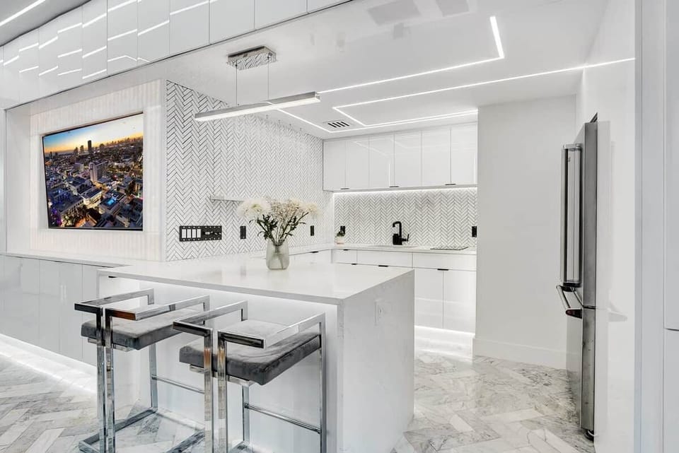 1st FLOOR: FULL BAR KITCHEN features full size Viking fridge, Viking drawer microwave, 2 burner cook top, sink, ceiling mounted champaign flutes, and bar seating for 2. Full kitchen accessories, cutlery, plates, cookware available.  